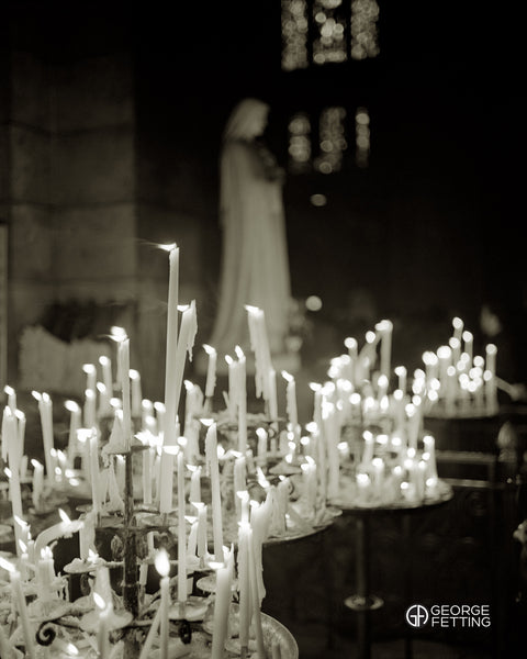A whisp of breeze caresses a candle within the Basilica Sacre Couer 