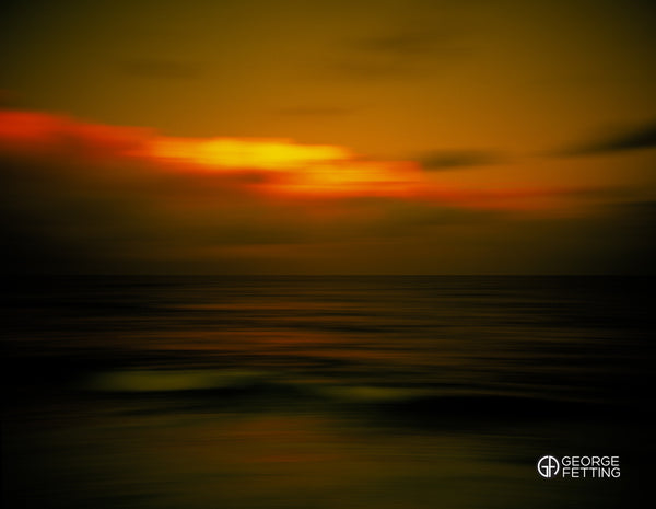 Buring late afternoon light above brooding seas