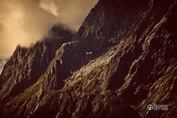 Awesome scale of Milford Sound is revealed by the miniscule passing plane 