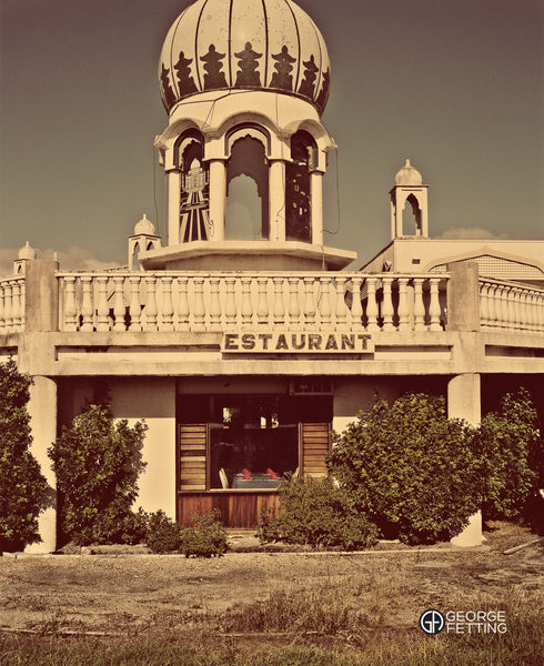 The fading facade of a roadside Indian Restaurant table settings intact